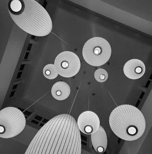 Abstract work by Mac Beach capturing an upward view of suspended illuminated forms arranged in a radial composition inside a hotel lobby in Delray Beach, Florida, 2026.
