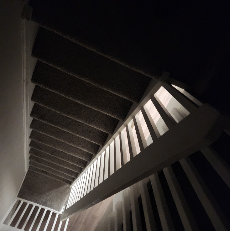 Abstract work by Mac Beach capturing an upward view of an illuminated railing and layered staircase inside a townhouse in Delray Beach, Florida, 2026.